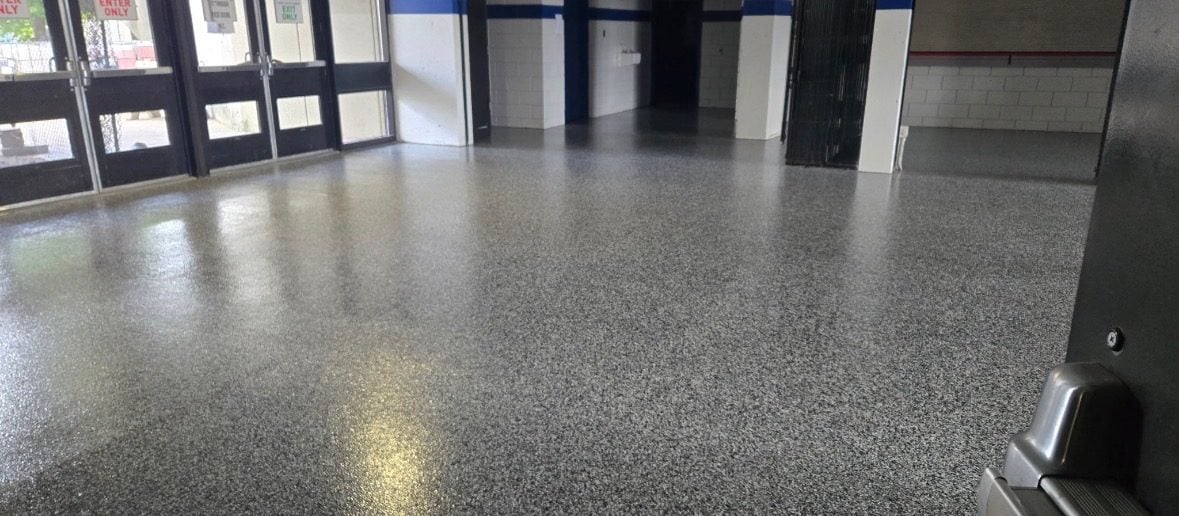 Gray and white flake floor in a commercial entryway lined with glass doors