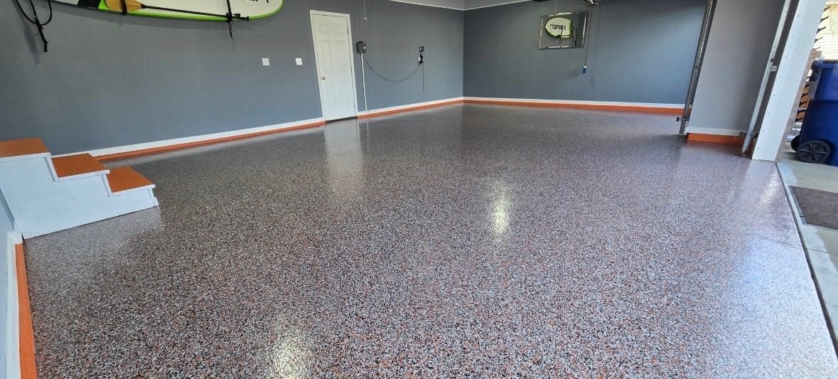 Red, gray and white flake garage floor with orange base trim and gray walls