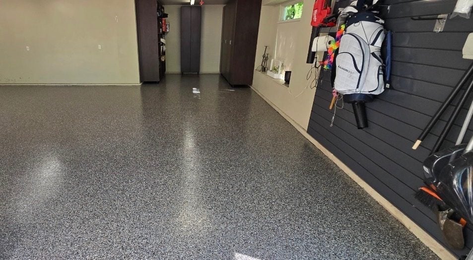 Gray and white flake garage floor with slatwall storage and a golf bag along the wall