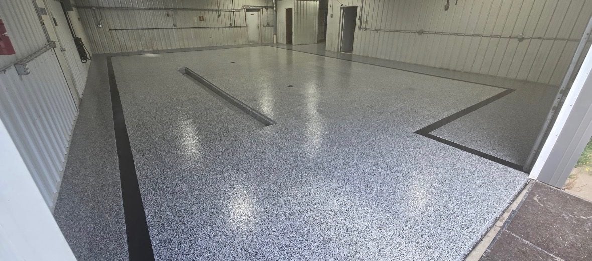 Gray flake shop floor with a custom black border stripe and a center drain trough