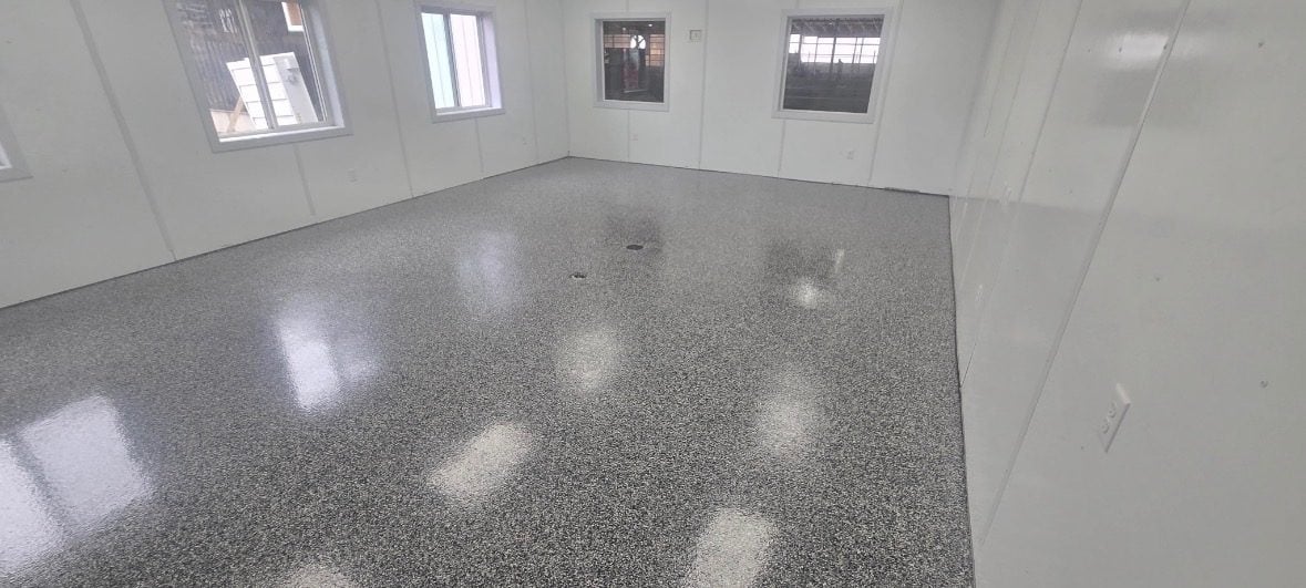 Gray, black and white flake floor in a white steel-paneled shop with windows