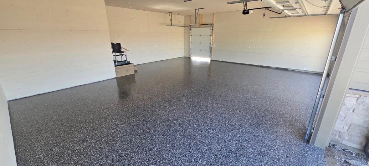 Gray and tan flake floor across a newly built two-stall garage